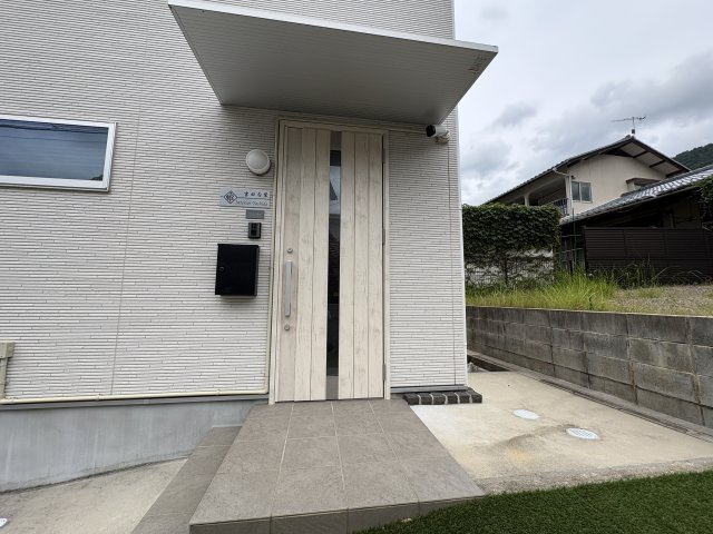 シンプルで上品なデザインの玄関アプローチです。屋根付きのため雨の日の出入りも安心。モニター付きインターホンや照明を備え、防犯面にも配慮されています。来客を気持ちよく迎えられる清潔感のある玄関まわりです