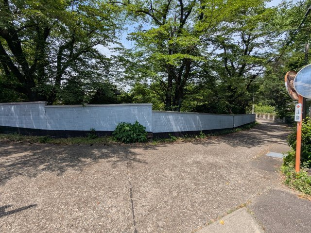 緑豊かで閑静な周辺環境。しっかりと囲われた白い塀が敷地のプライバシーと安心感を高めます。