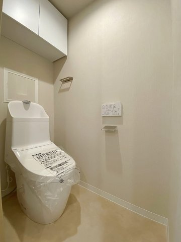 快適なウォシュレット機能を備えた新規交換済みの清潔なトイレ空間。毎日使う場所だからこそ、衛生面と居心地の良さにこだわりました。上部に収納スペースもあり、用品もすっきり収まります。