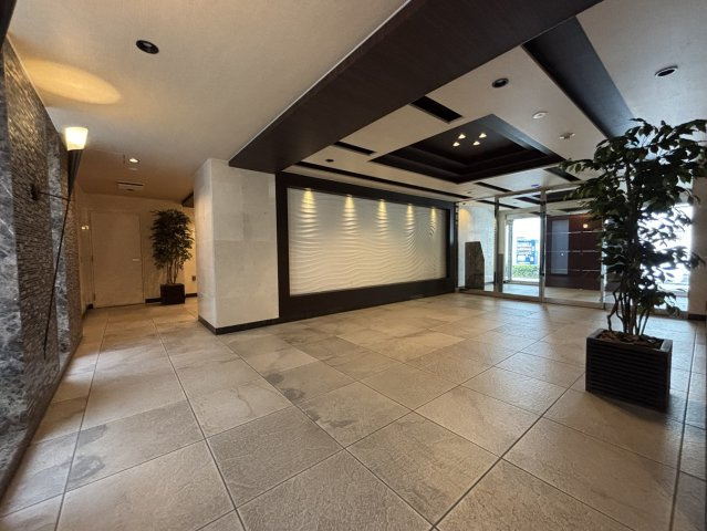 間接照明と天然石調タイルが迎賓空間を演出します。