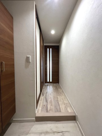 ダイニングの灯りがやわらかく差し込む廊下。木目建具で統一感のある空間です