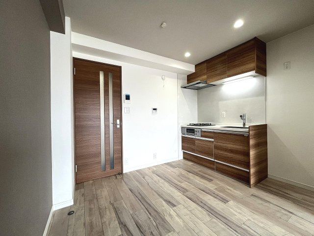 洋室から見たDK。木目キッチンと建具が調和した統一感ある内装です