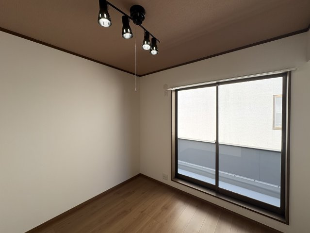 ベランダに面した大きな窓から光が差し込む開放的な洋室。通風も良く、一日を通して快適に過ごせます。引き戸の先に廊下が続き、家族の気配を感じながらもプライベートを保てる間取りです。