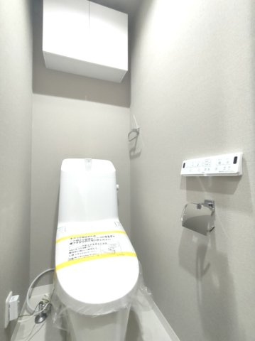【トイレ】　温水洗浄便座・壁付けリモコン付き。吊り戸棚を備えた機能的なトイレです。