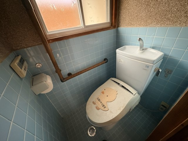 レトロなタイルが可愛らしいトイレ空間で、温かみのある雰囲気を感じられます。手すりも設置されているため高齢者の方でも安心して利用できます。リフォームプランのご提案もさせていただきます！