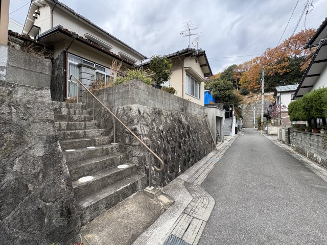 前面道路は落ち着いた住宅街に位置し、車通りも少なく安心して生活できる住環境です。敷地は道路より一段高く、プライバシーが確保される点も魅力。玄関へ続く階段には手すりが設置され、日々の昇り降りをサポート。