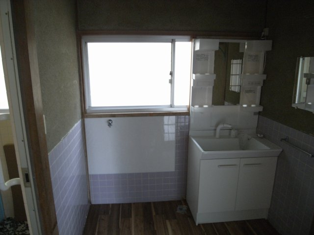 シャワー付きの洗面台が備わった洗面所は、朝の身支度や帰宅後の手洗いなど日常の使い勝手が良い空間です。大きな窓から自然光が入り、明るく清潔感があります。リフォームでさらに快適な空間へ再生可能です。