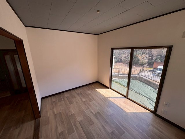 大きな掃き出し窓からたっぷりの自然光が差し込む明るい洋室。外の景色も楽しめる開放的な空間で、日中は照明いらずの心地よさ。ダイニングとの動線も良く、家族の集まる空間としても活用できます。　