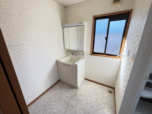 広さのある洗面室は、朝の支度や洗濯作業もスムーズに行える快適な空間。三面鏡付き洗面台は収納力が高く、散らかりがちな小物をきれいにしまえます。窓があるため明るく、自然換気がしやすいのもポイント。