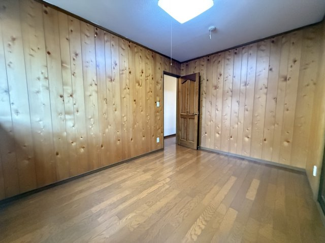 壁一面に木の温もりを感じる板張りを採用した洋室。ナチュラルで落ち着いた雰囲気が魅力です。シンプルな空間は家具の配置がしやすく、寝室や書斎など多目的に利用可能。心地よい木の香りに包まれる癒しの一室です。
