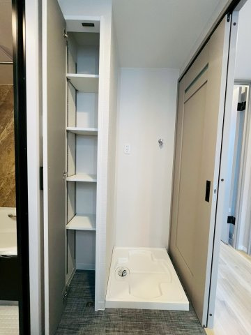 洗濯機を置く防水パンの隣には可動棚も。取り回しやすい位置に洗剤やタオルを置いておけます。