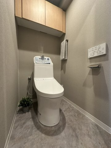 温水洗浄便座付のトイレで、冬の寒い時期でも快適！吊戸棚付きで、予備のペーパー類も問題なく収納できます。