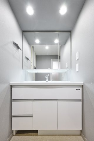 明るい照明と清潔感のある鏡面を備えた独立洗面化粧台。洗面ボウル下の収納や鏡まわりのスペースが充実しており、毎朝の身支度やアメニティ類の整理をスマートに行えます。
