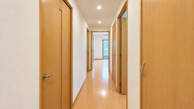 明るい木目調のフローリングと建具で統一されたすっきりとした廊下です。各居室や水回りへつながる動線が分かりやすく生活しやすい間取り。ダウンライトが空間を明るく照らし清潔感ある落ち着いた雰囲気になってます