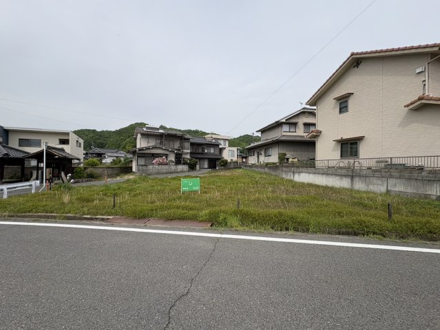 道路沿いから見た現地の様子で、敷地の広がりと開放感がしっかりと伝わります。建物配置の自由度が高く、平屋やゆとりある2階建て住宅など幅広いプランが検討可能。更地で建築条件なしのおすすめ物件です！