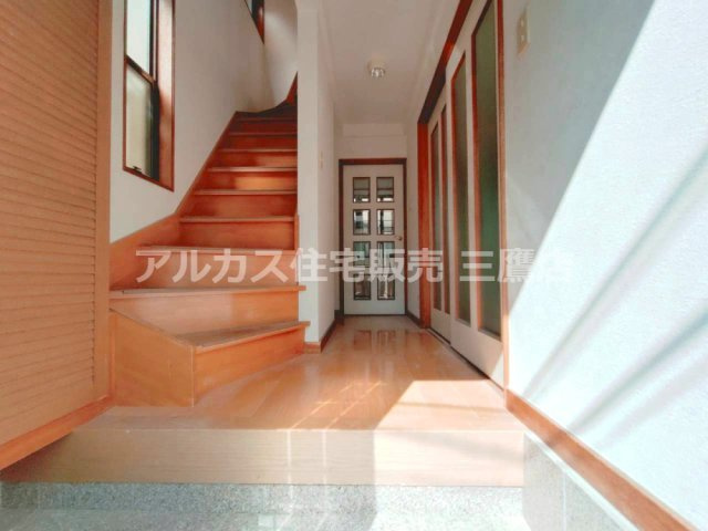 玄関から室内を見渡した様子。廊下沿いに階段や建具がまとまり、すっきりとした配置です。