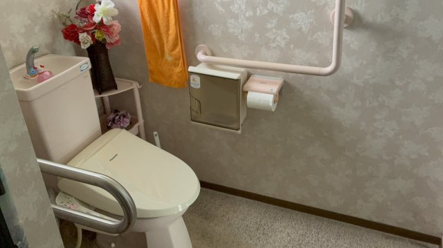 手すり付きで安心感のあるトイレ。温水洗浄便座に交換済みです。