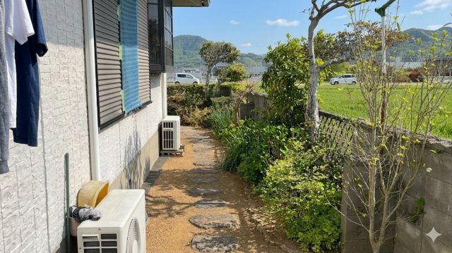 飛び石が配された情緒ある犬走り。家庭菜園も楽しめるスペース。