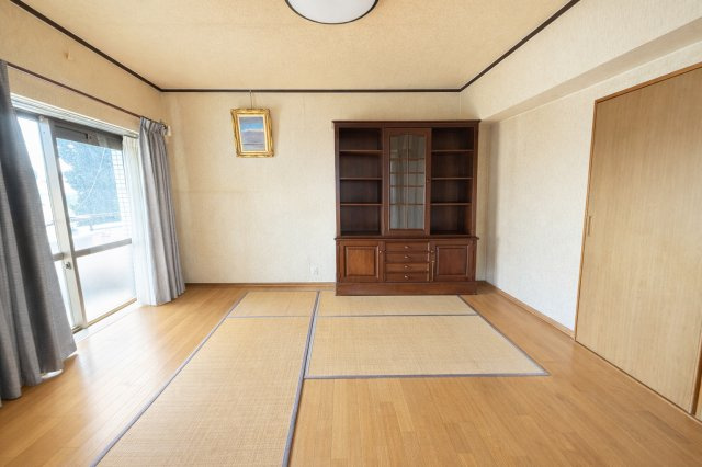 木目調フローリングが広がる明るい洋室です。大きな窓から自然光が入り、室内全体がやさしい雰囲気に包まれます。家具配置もしやすい間取りで、寝室や趣味部屋など多目的に利用可能となっています。