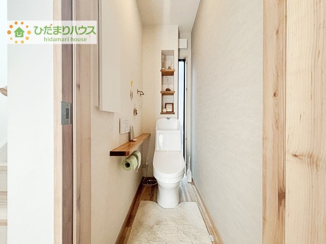 窓から自然光が差し込む明るいトイレ空間。すっきりとしたデザインに加え、収納付きカウンターを備え、使い勝手と清潔感を兼ね備えた快適な空間です。