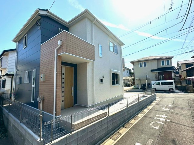 北本市中丸5丁目1区画　完成外観写真　　オフホワイト×ネイビーグレーの外観にナチュラルウッドをアクセントに配色しました。建物全体を明るく仕上げています。