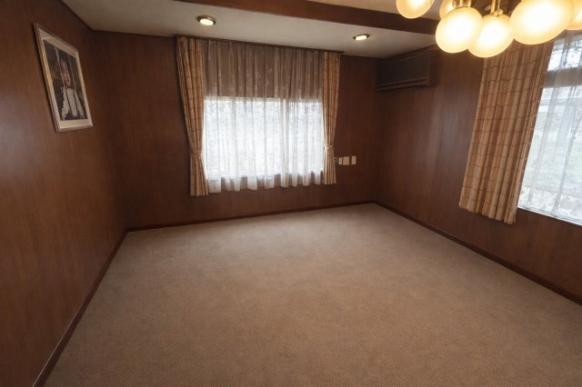 落ち着いた木目調の内装が魅力の洋室です。二面採光で明るさを確保し、室内は明るく開放感のある空間となっています。ゆとりある広さがあり、応接室としての利用にも適した上質で落ち着きのある空間です。