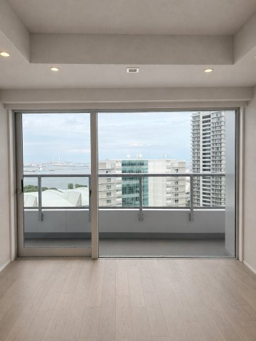 高層階ならではの開放的な景色を室内に取り込む、大きなガラス扉の開口部。バルコニー越しに広がる都市のパノラマを日常の背景にしながら、海を眺め、ゆったりとリラックスした時間を過ごせる特等席です。