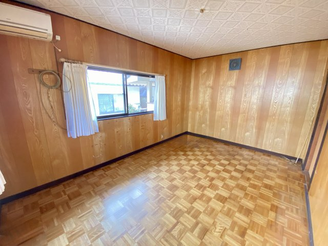 木目調の内装が落ち着きを感じさせる洋室。大きな窓から光が差し込み、明るく開放的な印象です。家具の配置もしやすく、寝室や趣味の部屋など幅広く活用できます。居心地の良い雰囲気が広がる快適な空間です。