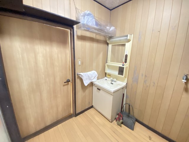 木目調の壁が温かみを感じさせる洗面スペース。洗面台には鏡付きの収納が備わり、日用品をすっきり整理できます。落ち着いた雰囲気の中で、朝の身支度や帰宅後のケアを快適に行えます。