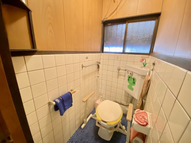 明るい印象のタイル張りトイレ。窓付きで換気がしやすく、清潔に保ちやすい空間です。手すりが設けられており、立ち座りの動作も安心。毎日使う場所だからこそ、使いやすさと快適さが感じられます。