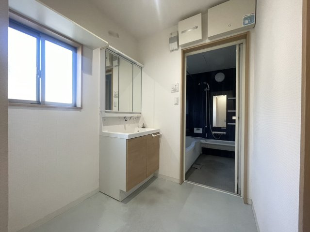 洗面室と浴室がまとまった家事動線の良いレイアウト。窓があるため自然光が入り、明るく換気もしやすい空間です。洗濯機置場にもゆとりがあり、日々の洗濯作業も快適。シンプルな内装で清潔感があります。