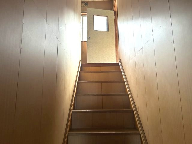 2階へと続く木製の直階段。上部に窓があり、足元まで光が届く設計