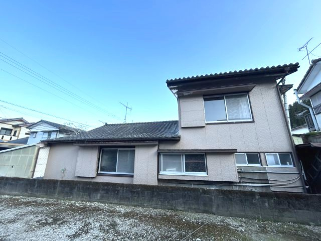 横から見た建物の全景。1階から2階にかけての段差がある形状