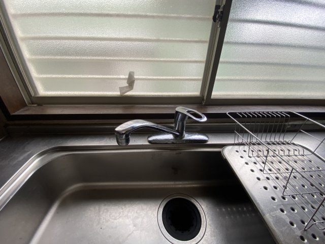 窓際に配置されたキッチンシンクは、手元に自然光が入り、明るく作業がしやすい環境が整っています。換気もスムーズで、料理中のこもったにおいも素早く解消。使い勝手の良いシンプルな蛇口デザインもポイントです。