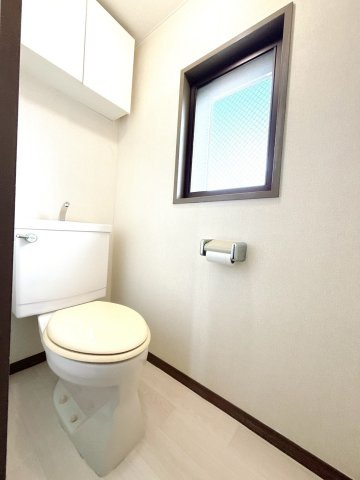 窓と扉付き収納棚のあるトイレ。ストック置き場に困りません