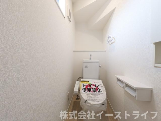 2号棟写真　落ち着いた色調のトイレで、温水洗浄機能付き便座です