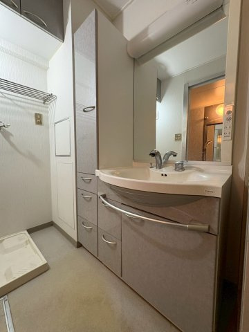 シャワー付きのワイドな洗面台、再度にリネン置場あり