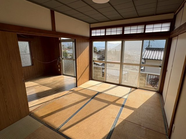 大きな掃き出し窓から明るい光が差し込む和室です。畳の温もりと開放的な眺望が魅力です。隣室とつなげて広く使うこともでき、来客時や家族団らんの場としても活躍します。高台ならではの景色を楽しめます。