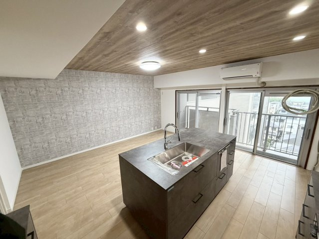 重厚感のあるキッチンデザインと木目天井が調和し、ホテルライクな住空間を演出します。