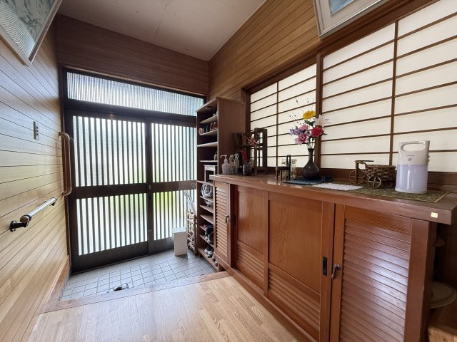 木の温もりを感じる広々とした玄関は落ち着いた雰囲気で来客を迎え入れます。大きな下駄箱収納が備わり、靴や小物をすっきり整理可能。採光窓から光が差し込み明るく、和の趣と機能性を兼ね備えた心地よい空間です。