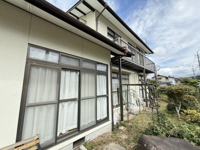 窓が並ぶ外観は日当たりと通風に優れた心地よい住環境を演出します。庭には植栽もあり季節の移ろいを感じられる落ち着いた空間です。縁側のように活用できる外周スペースは洗濯物干しやくつろぎの場としても便利です