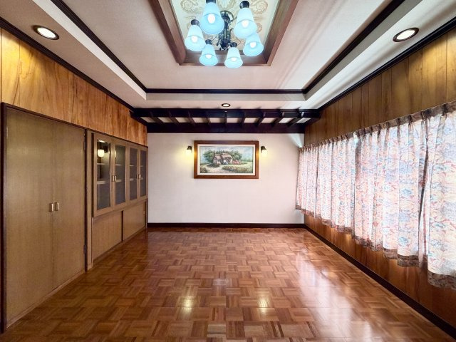 木目調の内装が印象的な洋室。パーケットフローリングが上質な雰囲気を演出します。天井のデザイン照明や壁面収納があり、個性ある空間に仕上がっています。主寝室や趣味のお部屋にもおすすめです。