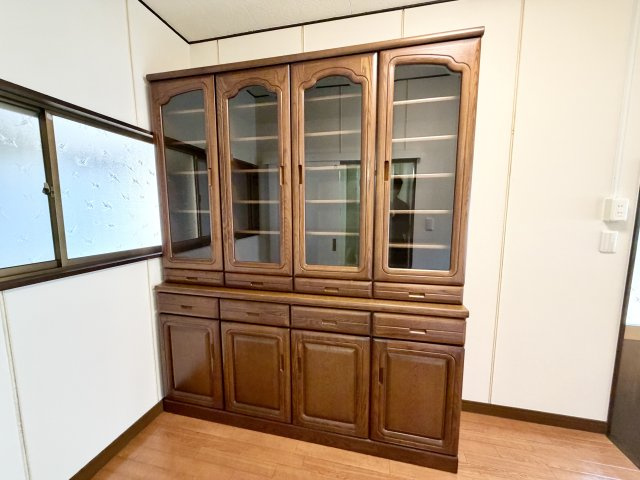 重厚感のある木製の食器棚を設置されています。上下に分かれた収納で、食器や調理器具をしっかり整理できます。窓からの光も入り、明るい空間。キッチン周りの収納力を高め、日々の家事をサポートします。