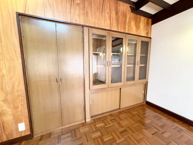 壁一面に設けられた大型収納。ガラス扉付きの棚とクローゼットが一体となっており、衣類や書籍、コレクションの収納にも便利です。収納量が豊富で、お部屋を広く使うことができます。