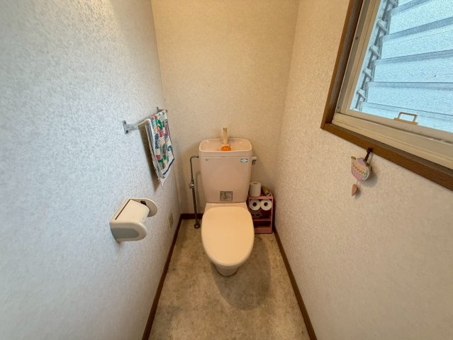 窓付きで自然換気ができる明るいトイレ空間。シンプルな設計でお掃除もしやすく、毎日気持ちよくご使用いただけます。壁面にはタオル掛けも備わっており、使い勝手にも配慮。1階にあるため来客時にも便利です。