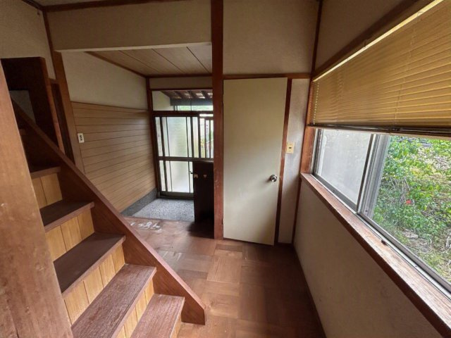 木目調の壁板と階段横の大きな窓から入る自然光が調和します
