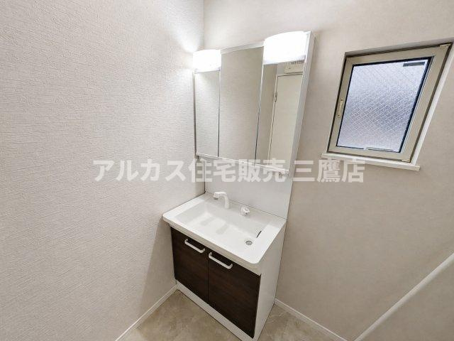 清潔感あふれる三面鏡付きの洗面化粧台。機能性と収納力を兼ね備えた快適な空間です。