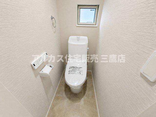 小窓からやわらかな光が入る清潔感のあるトイレ。小物を置けるスペースも備わっています。