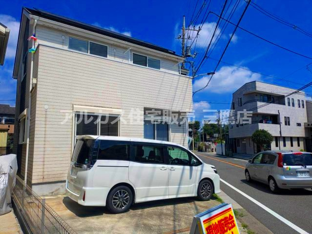 白を基調としたモダンな外観デザイン。敷地内には便利な駐車スペースを備えています。