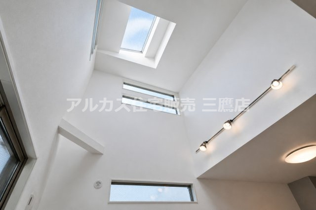 天窓と高窓を備えた吹き抜け。壁面のスポットライトが、縦方向の広がりを印象的に演出します。　